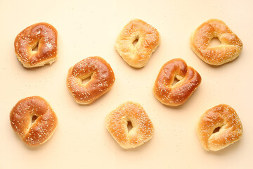Tasty bagels with sesame seeds on beige background