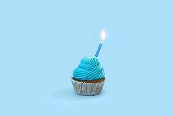 Tasty cupcake with birthday candle on blue background