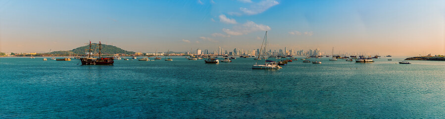 Fototapeta premium A panorama view past moored boats towards the skyline of modern Panama City in the early morning in springtime