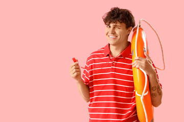 Male lifeguard with whistle and ring buoy on pink background