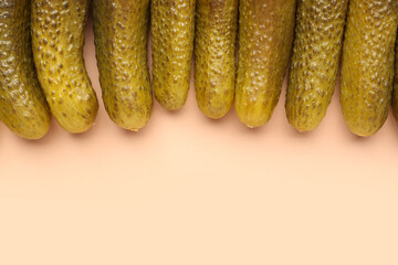 Pickled cucumbers on orange background