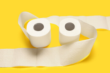 Rolls of toilet paper on yellow background