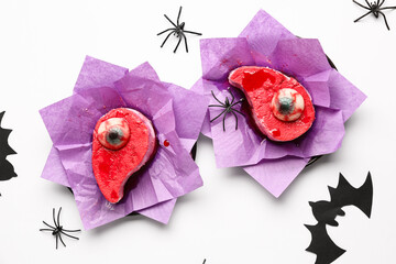 Composition with delicious fruit cakes in paper, spiders and paper bat for Halloween celebration on...