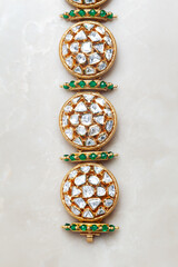 Close-up of a diamond bracelet adorned with various stones and gems placed over a marble background.