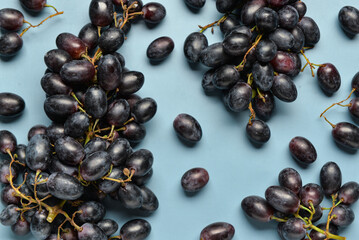 Sweet black grapes on blue background