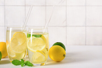 Glasses of tasty lemonade with mint on white table