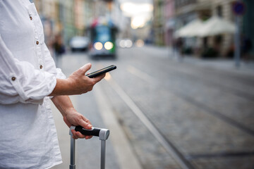 Woman tourist buying online ticket to tramway with mobile app on her smart phone. Travel by public transportation in city