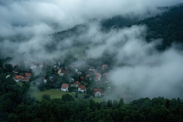 Aerial view of Ringelbach village shrouded in fog amidst lush green hills in Germany, Aerial view around the village Ringelbach in Germany in the black forest on a cloudy day in summer