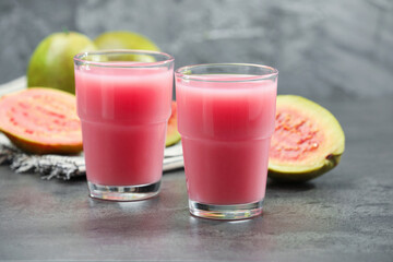 Refreshing guava juice and fresh fruits on grey table, closeup