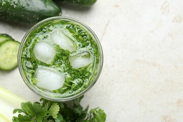 Healthy drink with parsley and cucumbers on light table, flat lay. Space for text