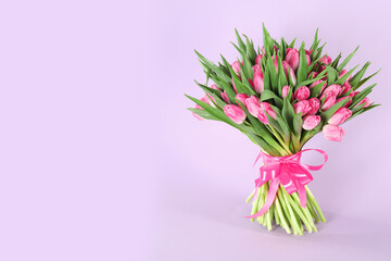 Obraz premium Bouquet of beautiful tulips on lilac background, space for text