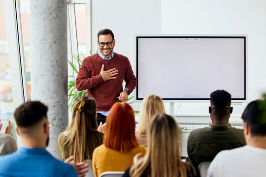 Professional Man Delivering Inspirational Presentation to Engaged Audience in Modern Office