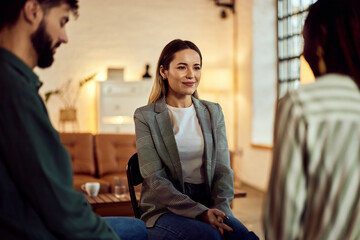 Group Discussion in a Cozy Room with Focus on Woman Smiling