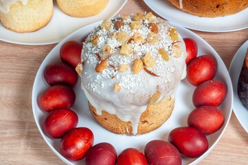 A beautifully decorated Easter cake with candied fruits and red eggs adorns a festive table for the holiday.