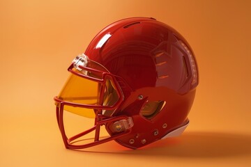 Fototapeta premium A red football helmet with a facemask and visor is isolated on an orange background, Showcase the iconic shape and structure of a football helmet