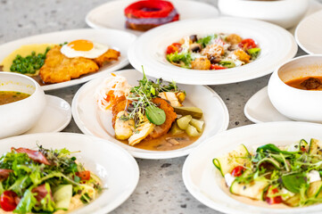 A variety of delicious dishes arranged on a table, featuring vibrant salads, flavorful soups, and hearty main courses, showcasing fresh ingredients and appealing presentation.