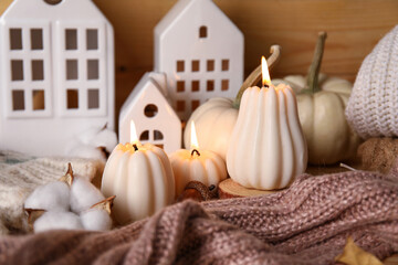 Beautiful composition with candles, pumpkins and autumn decorations on brown wooden background