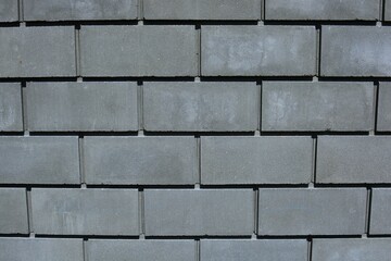 Wall background of dark grey bricks.Grey brick wall background. Dark grey wall closeup.