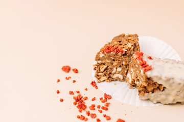Dessert chocolate bar made at home, milk chocolate with nuts, Sublimated raspberries next to each other on a beige background