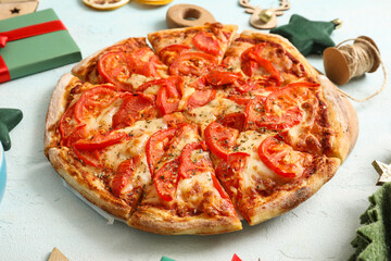 Wooden board with delicious pizza and Christmas decor on white background