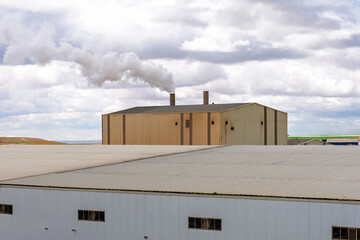 Smoke stacks from an industrial facility against a cloudy sky in Setif City, Algeria.