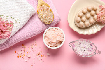 Composition with body scrub, sea salt and clean towels on pink background