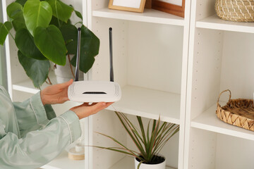 Woman with wi-fi router at home, closeup