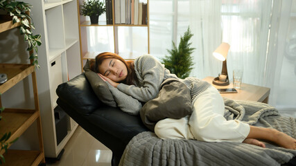 Young woman napping comfortably on a recliner in a cozy living room