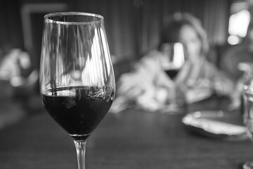 dinner in a restaurant with wine, beautiful table setting, a glass of wine in the foreground