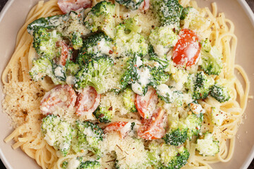 Plate of tasty pasta with broccoli, cheese and tomatoes, closeup