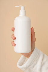 Woman holding bottle of natural cream on color background, closeup