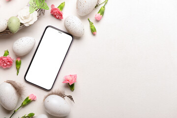 Composition with modern mobile phone, Easter eggs and flowers on light background