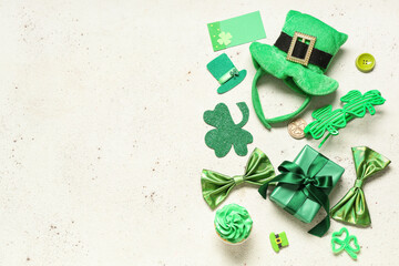 Leprechaun hat with cupcake, gift box and decor for St. Patrick's Day on white grunge background