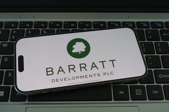 Kiel, SH, Germany, 04-01-2025 Barratt Developments PLC logo displayed on a smartphone resting on a laptop keyboard, emphasizing modern connectivity and corporate branding