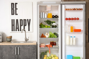 Open big fridge with fresh products in kitchen