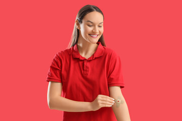 Female blood donor with applied patch on red background