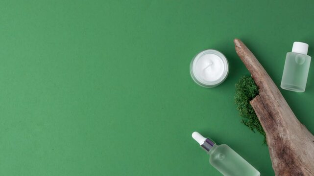 Skin care products on green moss natural background with wood. Flat lay, copy space.