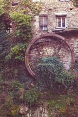Ancient Stone Mill with Mossy Waterwheel in Rural Setting