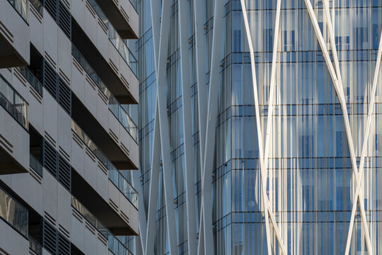 Diagonal reflections on glass building with dynamic vertical elements, high-rise facade ideal for modern urban architecture and premium abstract city design content