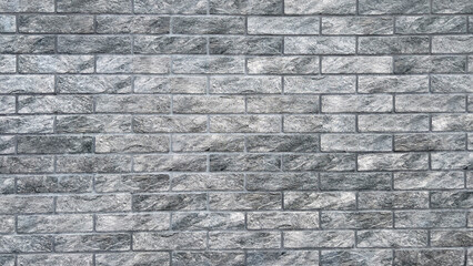 The background is a gray artificially aged brick wall. A modern stone fence.