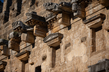Part of the stone wall of the ancient amphitheater with architectural elements.