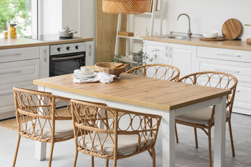 Dining table with wicker chairs in light kitchen