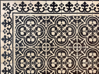 Colonial heritage tiles in random classic geometric floral, star, and ornamental patterns. Handmade colonial tiles, or old heritage tiles in black and white paint. Seamless texture.