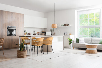 Interior of dining room with chairs, table and houseplants