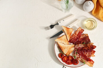 Fried bacon with toasts and dried tomatoes on plate on white background. Top view