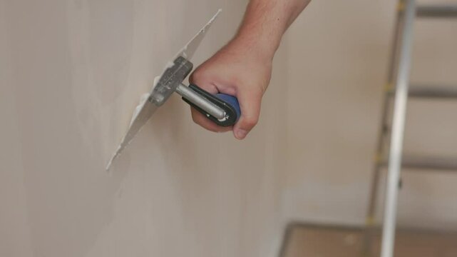 Applying plaster to a wall using a trowel