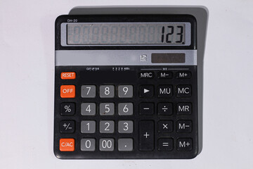 Close-up of a vintage black calculator displaying 123.