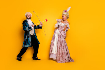 Elegant couple in royal costumes celebrating together on a bright yellow background