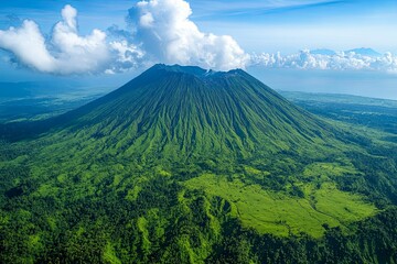 A lush green volcano surrounded by vibrant blue sky and clouds
