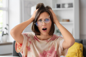 Stressed teenage girl filling out college application form at home